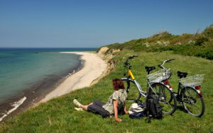 Fahrradfahrerin mach eine Pause an der Ostseeküste